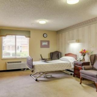 A well-lit hospital room with a medical bed and comfortable seating.