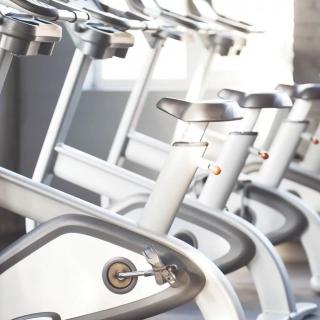 A row of exercise bikes in a gym ready for indoor cycling sessions.