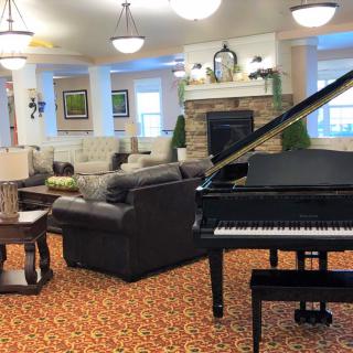 A cozy living room featuring a grand piano and comfortable seating arrangements.