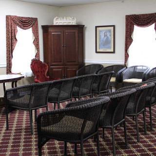 A small meeting room with arranged chairs and carpeted flooring.