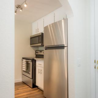 A compact modern kitchen with stainless steel appliances and white cabinetry.