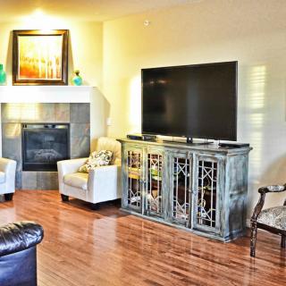 A cozy living room with a TV, fireplace, and comfortable seating.