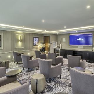 A modern conference room with comfortable seating and a large screen.