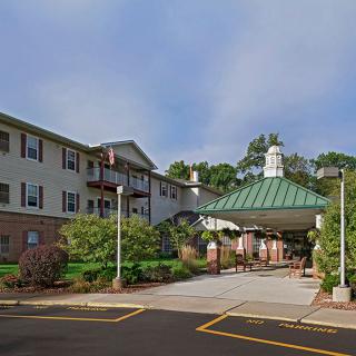 An inviting entrance to a multi-story building with a green roof and well-maintained landscaping.