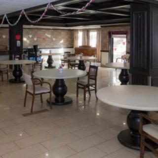 An empty restaurant interior featuring round tables and elegant chairs.