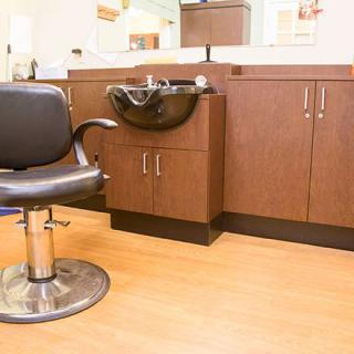 A modern hair salon setup with a styling chair and washbasin.