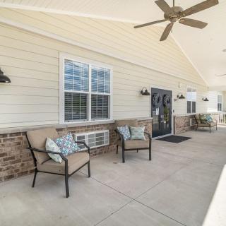 A cozy outdoor patio area with chairs and a ceiling fan.