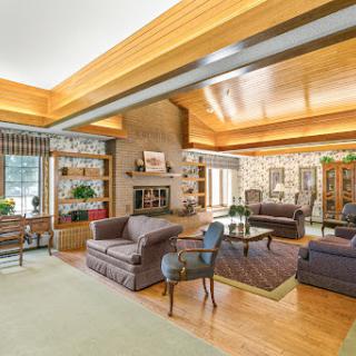A spacious and inviting living room featuring elegant furniture and warm wooden accents.