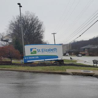 A sign for St. Elizabeth Health located by the roadside on a cloudy day.