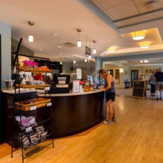 Customers standing at a modern cafe counter with warm interior lighting.