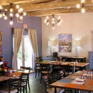 A cozy restaurant interior with wooden tables and modern lighting.