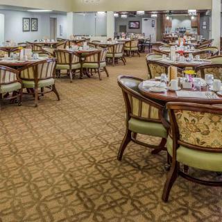 A spacious dining area with elegantly set tables and chairs.