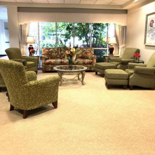 A cozy living room with comfortable seating and a view of the outside garden.