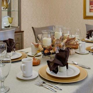 A beautifully arranged dining table set for a formal dinner with elegant place settings and decorative candles.