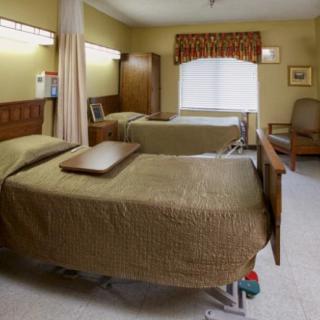 A shared hospital room with two beds and a window view.