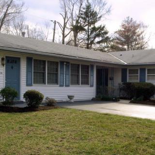 A suburban ranch-style house with a driveway and front yard.