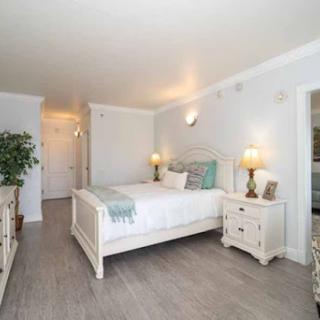 A bright and cozy bedroom featuring a white bed frame, soft bedding, and stylish decor.