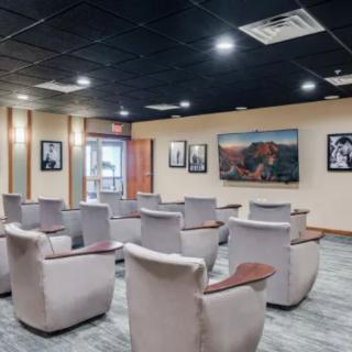 A modern conference room featuring comfortable seating and wall-mounted artwork.