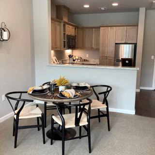 A modern open-plan kitchen and dining area with a round table set for four.