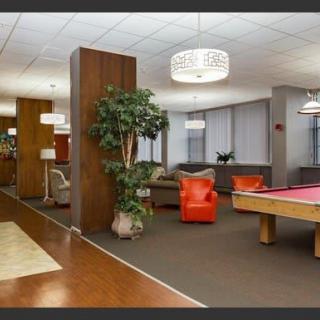 A modern lounge area featuring a pool table, comfortable seating, and stylish lighting.