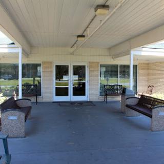 A spacious outdoor seating area with benches, providing a welcoming entrance to the building.