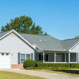 A suburban house with a well-maintained lawn and a driveway.