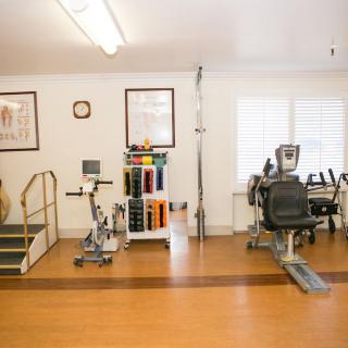 A physical therapy room equipped with various exercise machines and equipment.
