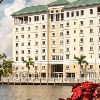 A waterfront hotel with palm trees and a serene atmosphere.