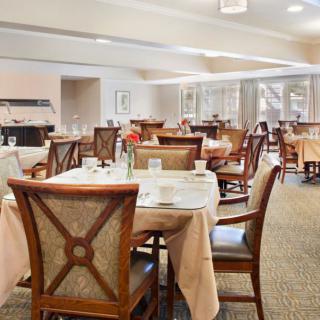 A spacious dining area with neatly arranged tables and chairs, ready for guests.
