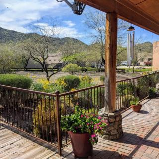 Scenic mountain view from a cozy porch with potted plants.