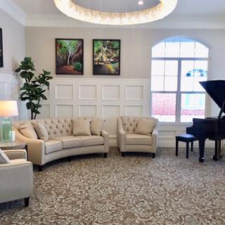 A cozy living room featuring elegant seating and a grand piano.