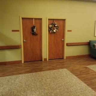 A cozy waiting area featuring two wooden doors adorned with seasonal wreaths.