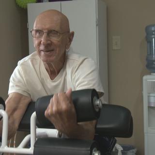 An elderly person engaging in exercise with gym equipment.
