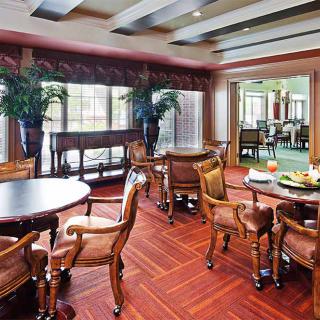 A stylish dining area with elegant wooden furniture and lush potted plants.