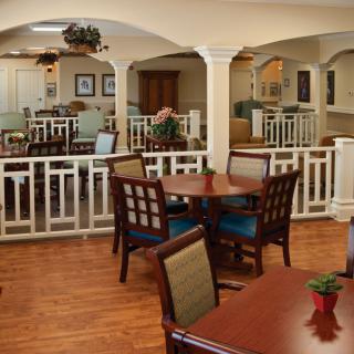 A cozy dining area with wooden tables and chairs, featuring elegant decor and a warm ambiance.