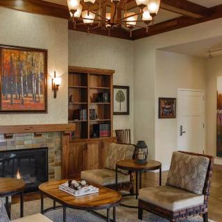 A cozy living room with a fireplace, comfortable seating, and elegant decor.