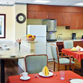 A modern kitchen and dining area with neatly set tables and contemporary furniture.