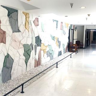 A brightly lit hallway featuring an abstract mural on the wall.