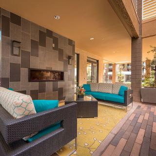 A modern outdoor seating area with stylish furniture and a cozy fireplace.