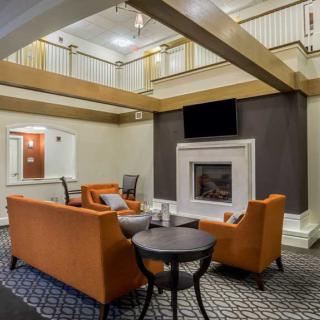 A modern living space with orange sofas and a fireplace in a hotel lobby.