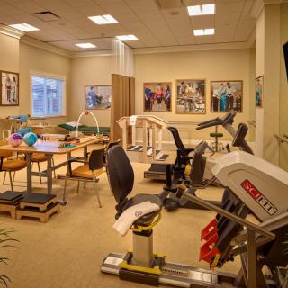 A well-equipped physical therapy and rehabilitation room with exercise machines and equipment.