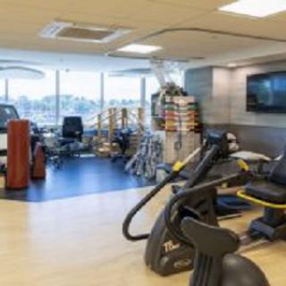 A spacious gym with various exercise equipment and cardio machines.