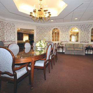 A spacious dining room featuring elegant furniture and decorative walls.