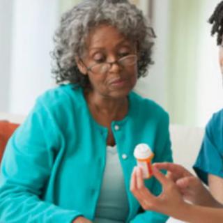 An elderly woman consults with a healthcare professional about her medication.