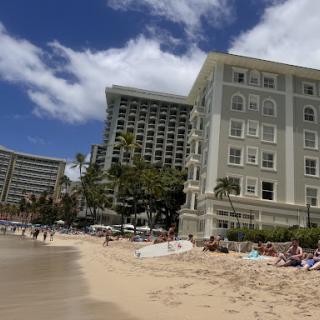 A sunny beach scene featuring hotels and a clear sky.