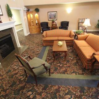 A cozy living room with sofas, a fireplace, and decorative elements.