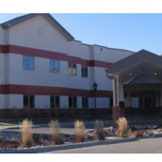 A modern commercial building with a welcoming entrance and landscaped surroundings.