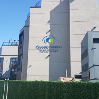 A modern building featuring a colorful logo against a clear blue sky.