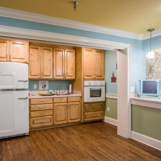 A vintage-style kitchen with wood cabinets and a retro white refrigerator.