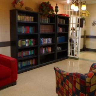 A cozy reading area with a bookshelf filled with books and comfortable seating.
